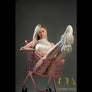 Realistic Evelina sex doll by MyRealDolls with detailed facial features and lifelike skin, showcasing the full doll in a seated pose.